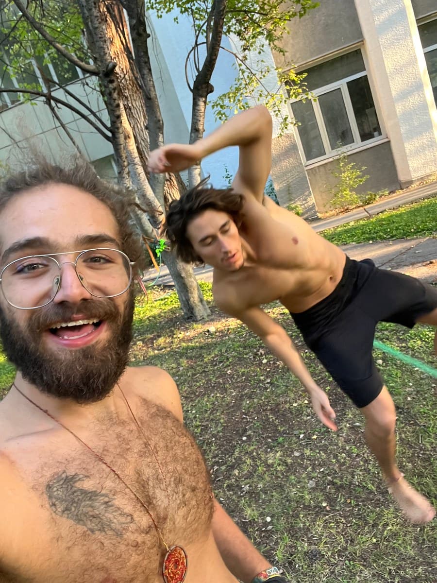 Önde gülümseyen bir arkadaş, arkada Türker slackline üzerinde