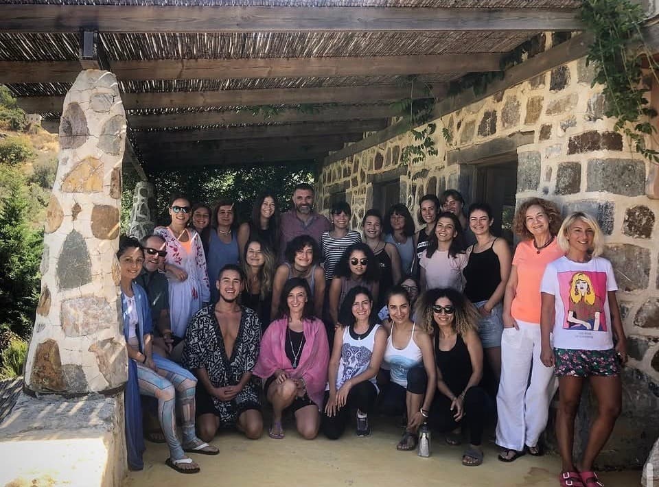 Taş bir binanın sundurması altında Mindfulness Kampı katılımcılarıyla grup fotoğrafı